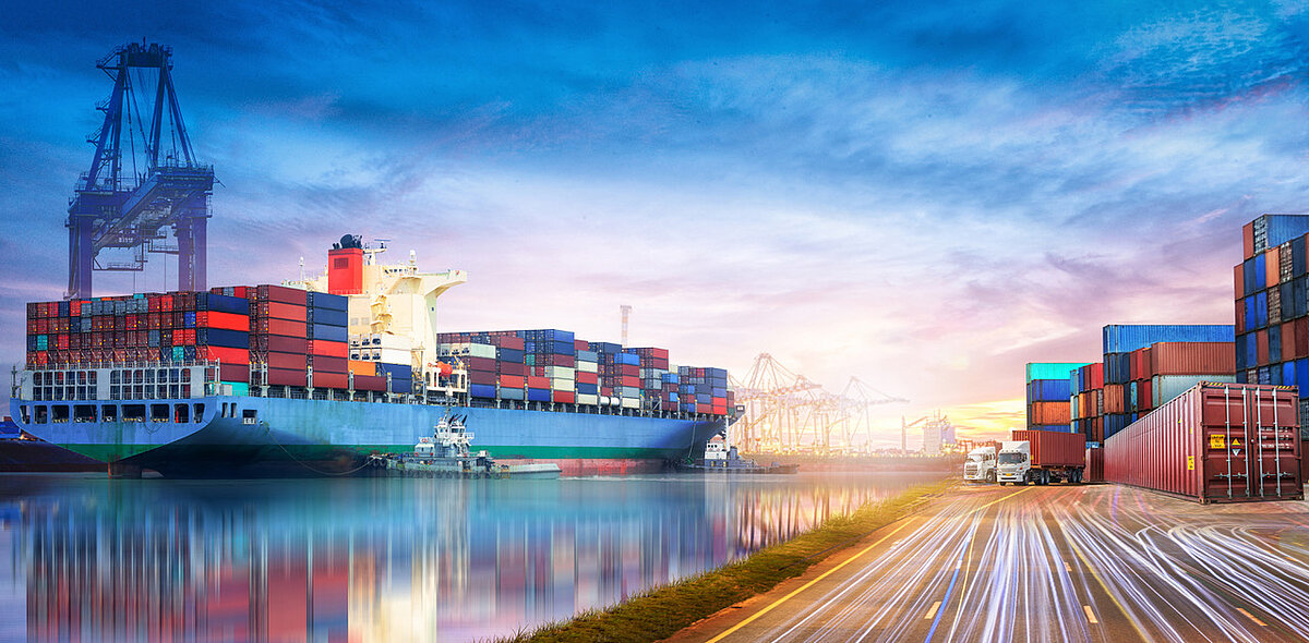 Transportschiff mit Containern am belebten Umschlaghafen