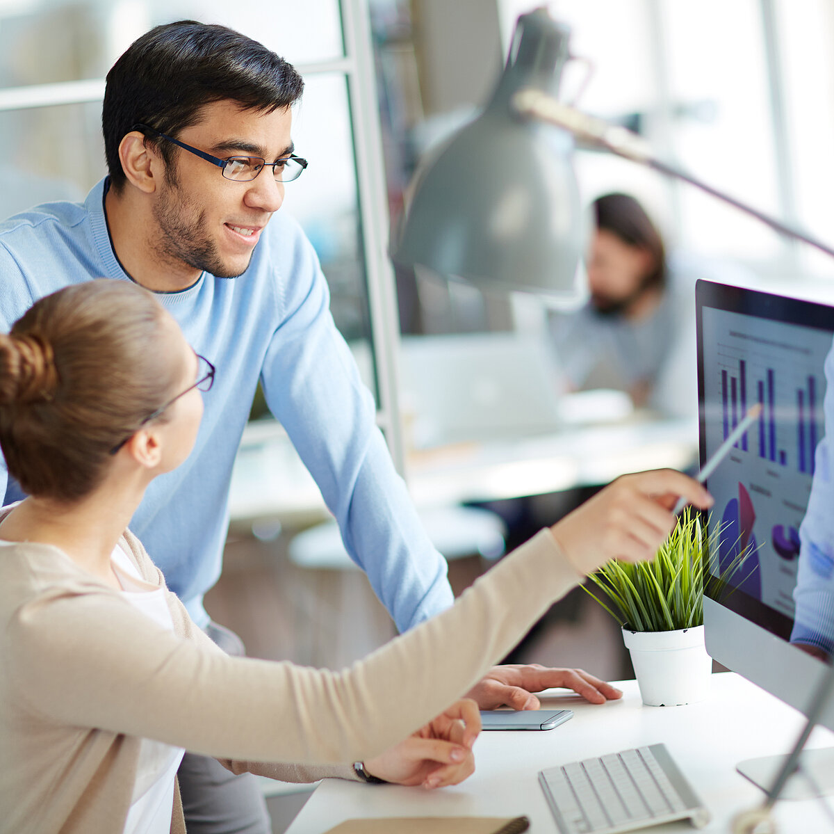 Woman explaining a graphic to a man on the screen